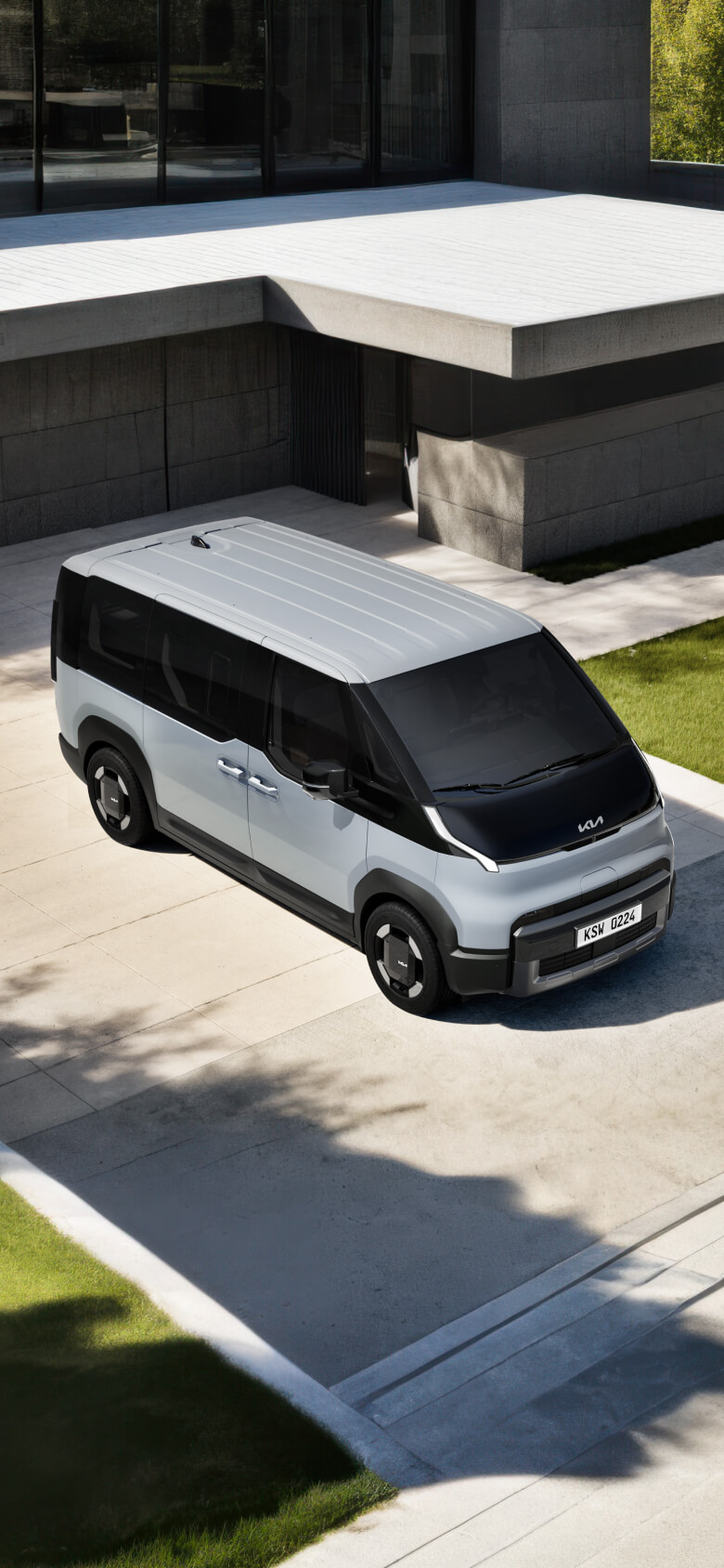 Frontansicht des Kia PV5 Passenger in einer Einfahrt im Freien