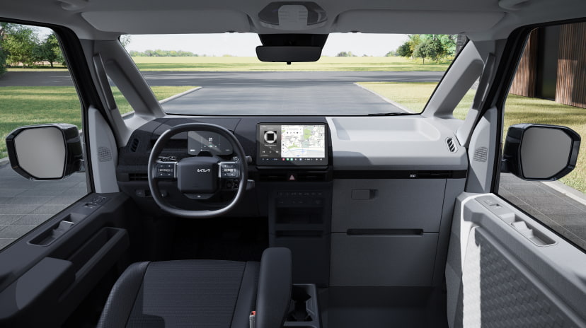 Vordere Innenansicht des Kia PV5 Passenger mit Panorama-Windschutzscheibe und Armaturenbrett